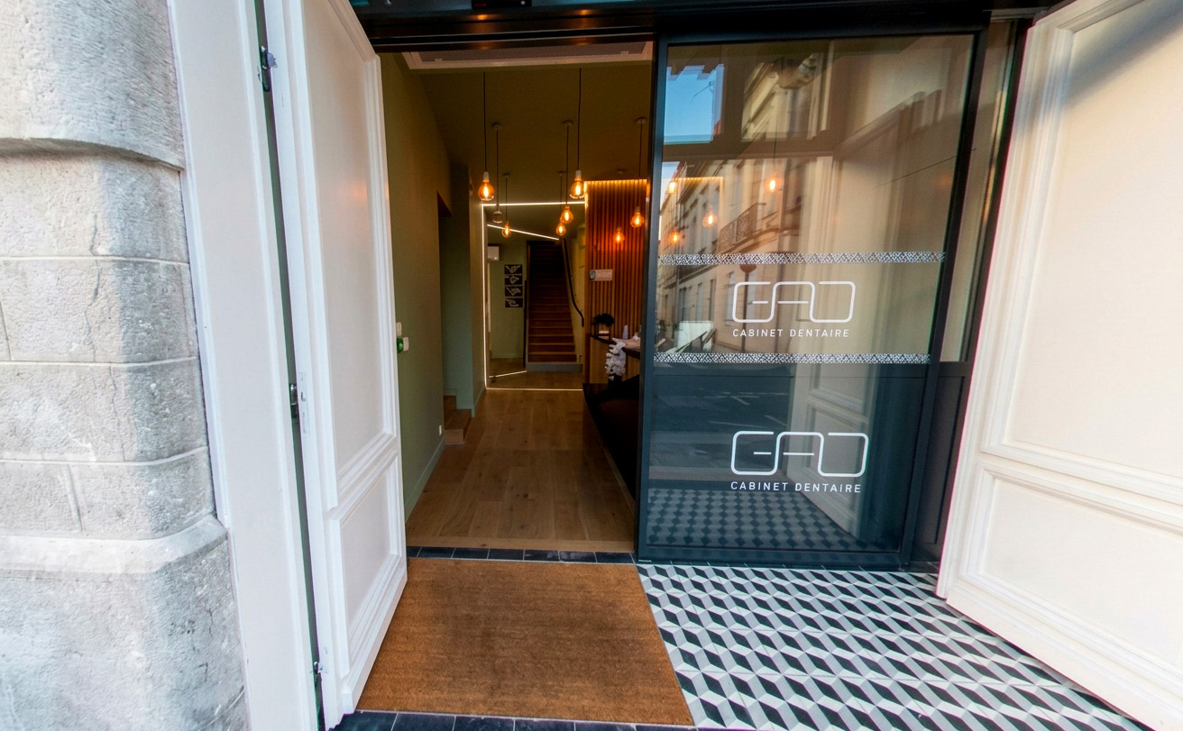 Détail des matériaux bruts et du mobilier métal noir, signature d'un architecte cabinet dentaire à Bordeaux
